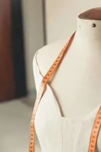 Measuring tape draped on dress form mannequin