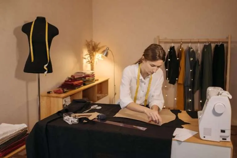 Woman making a sewing pattern on a cutting table