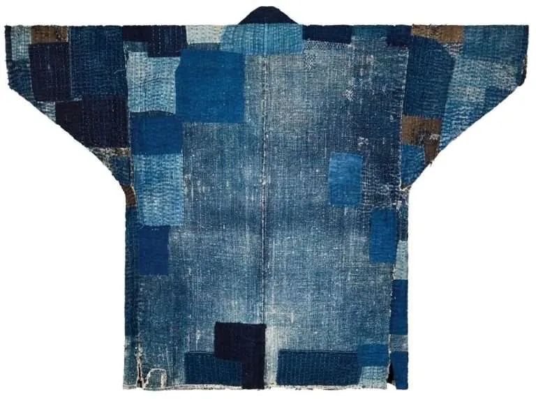 Antique Japanese boro cotton coat covered in overlapping patches and visible mending stitches