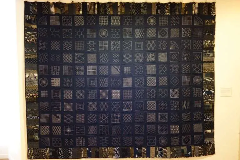 Sashiko running stitch worked in white thread on indigo cotton in a geometric grid pattern